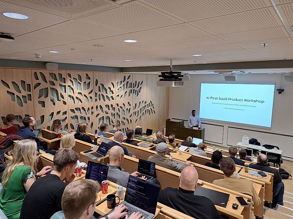 Audience in a seminar room during an 'AI-First SaaS Product Workshop' presentation by a speaker.