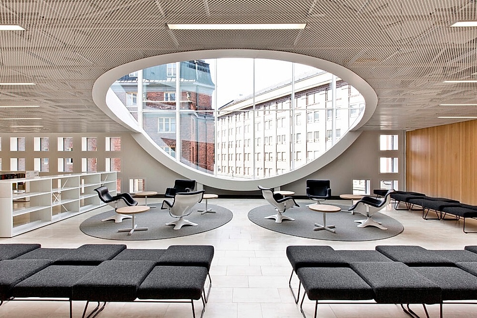 Modern office space featuring circular windows, gray seating, and a minimalist design aesthetic.