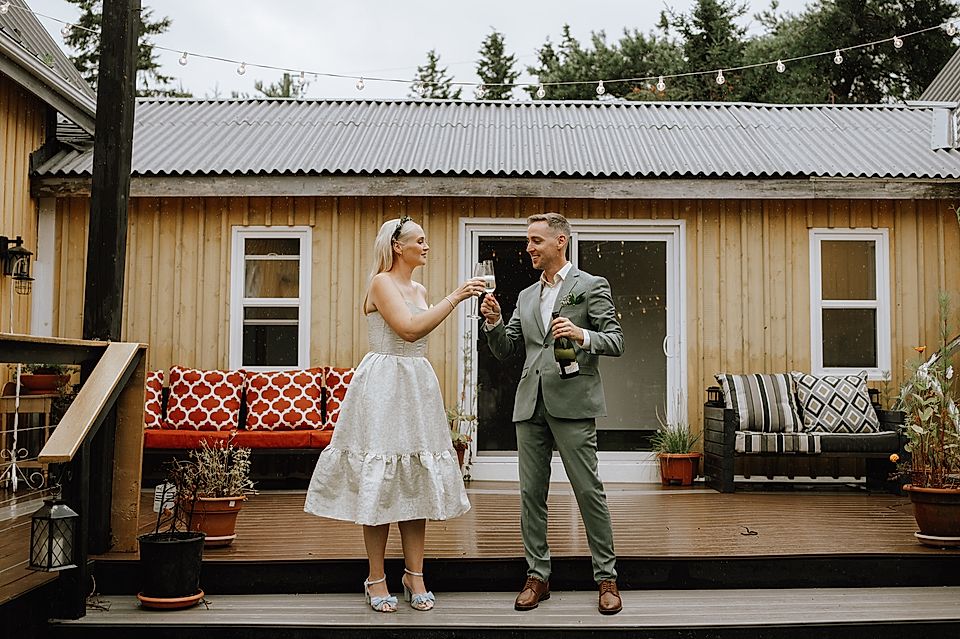 Bride and groom toasting with champagne on a decorated outdoor deck
