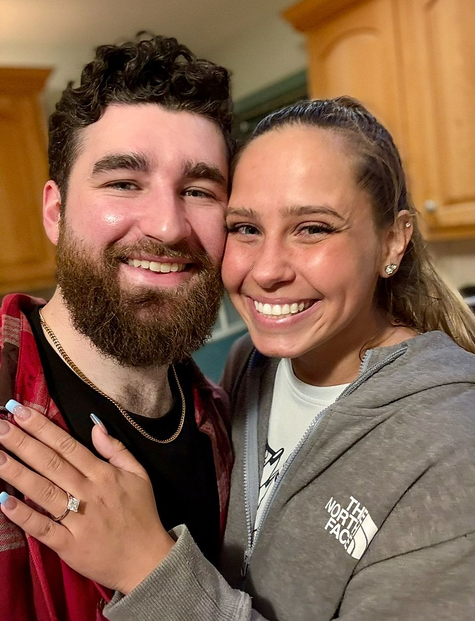 Smiling couple posing for a close-up selfie in a kitchen